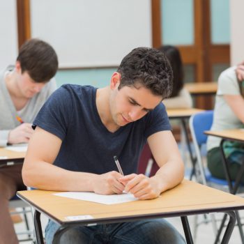 Elever som skriver ett prov med papper och penna