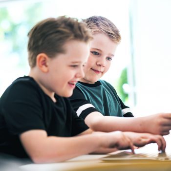 Tvåpojkar sitter framför en datorskärm